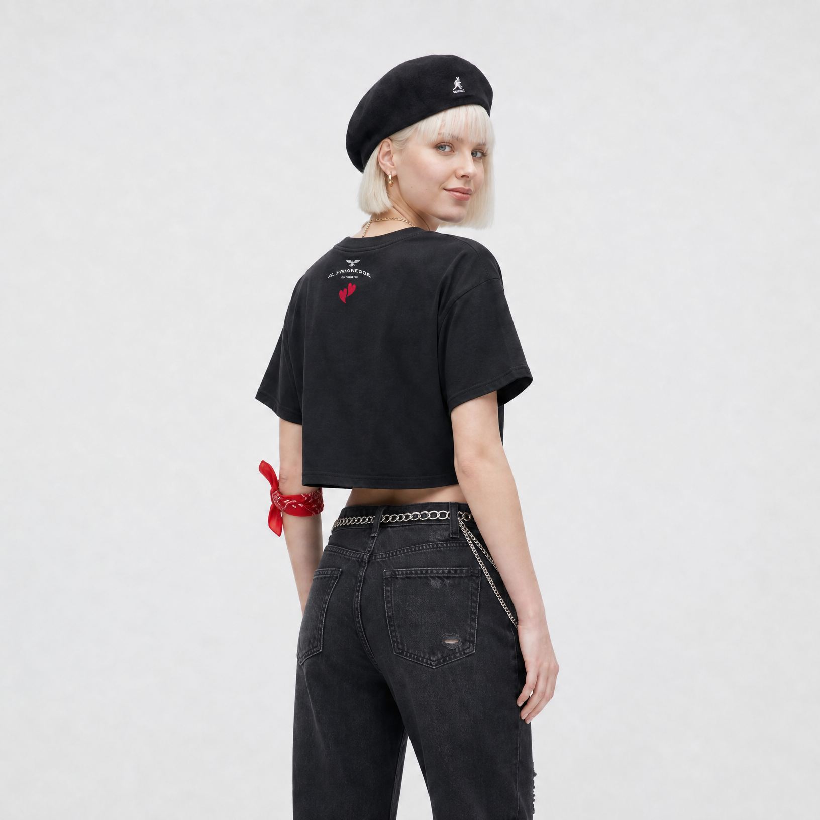 Person wearing a black t-shirt with a red design, black beret, and black jeans on a white background