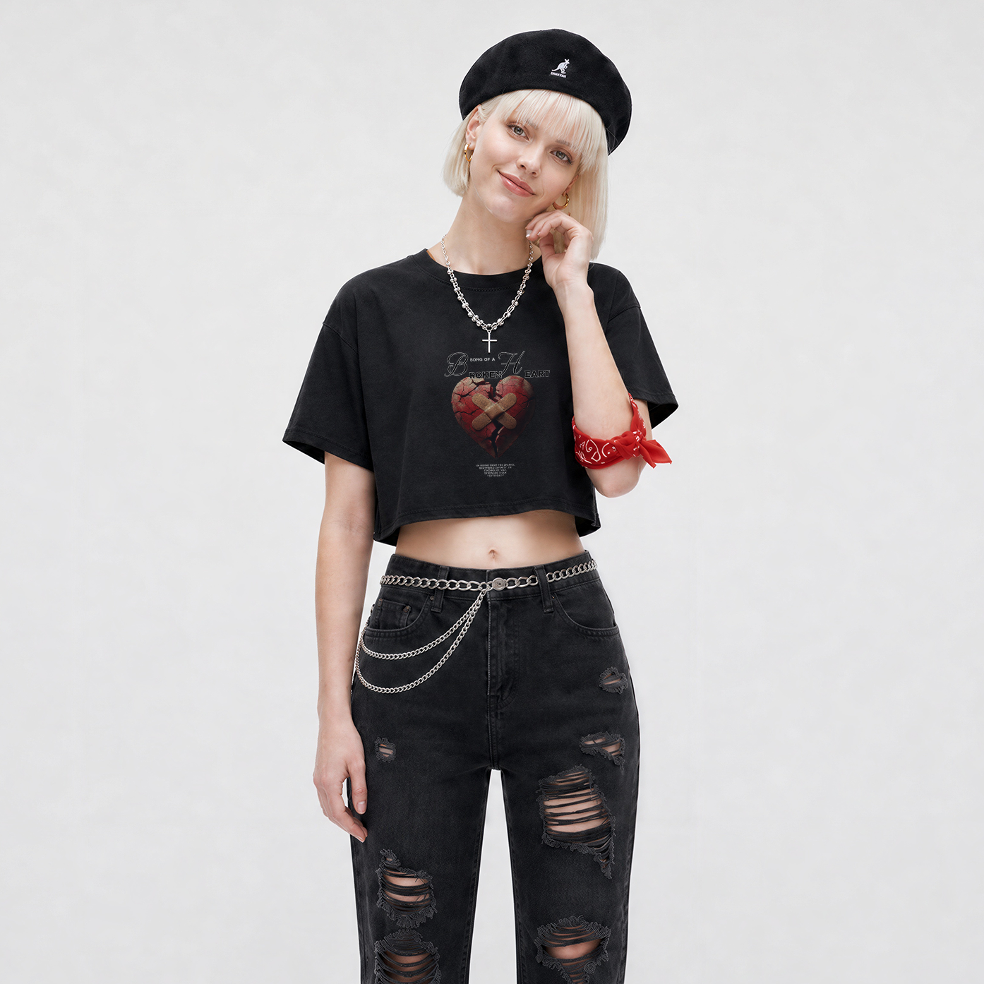 Person wearing a black t-shirt, black ripped jeans, and a black beanie on a white background