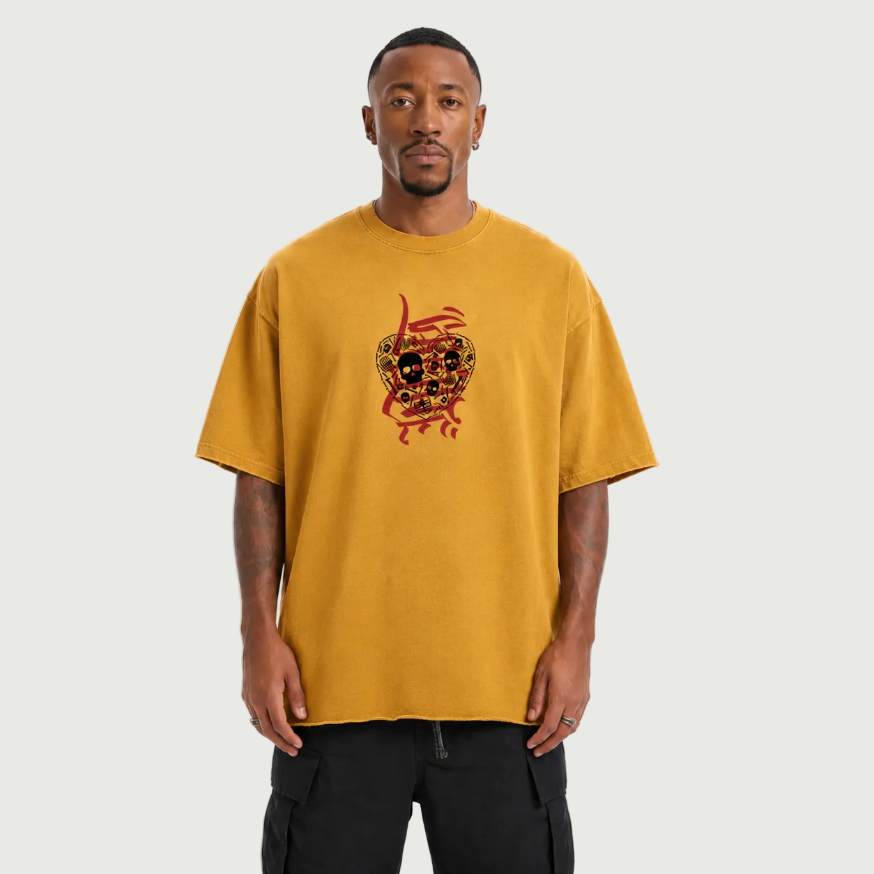 Man wearing a mustard yellow t-shirt with a graphic design on a white background
