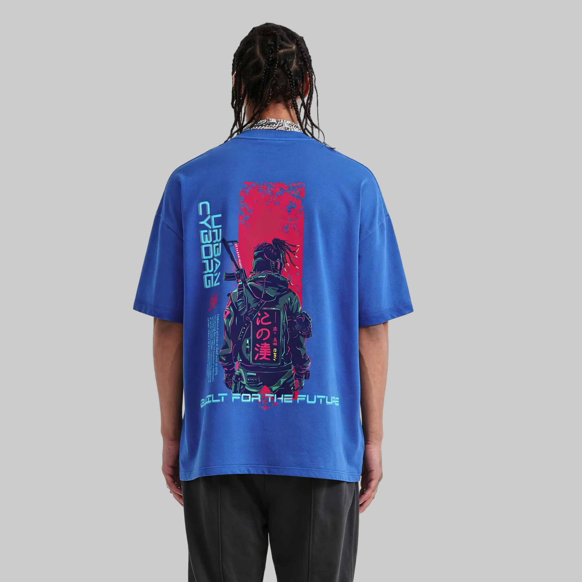 Person wearing a blue t-shirt with a graphic design on the back, standing against a plain background