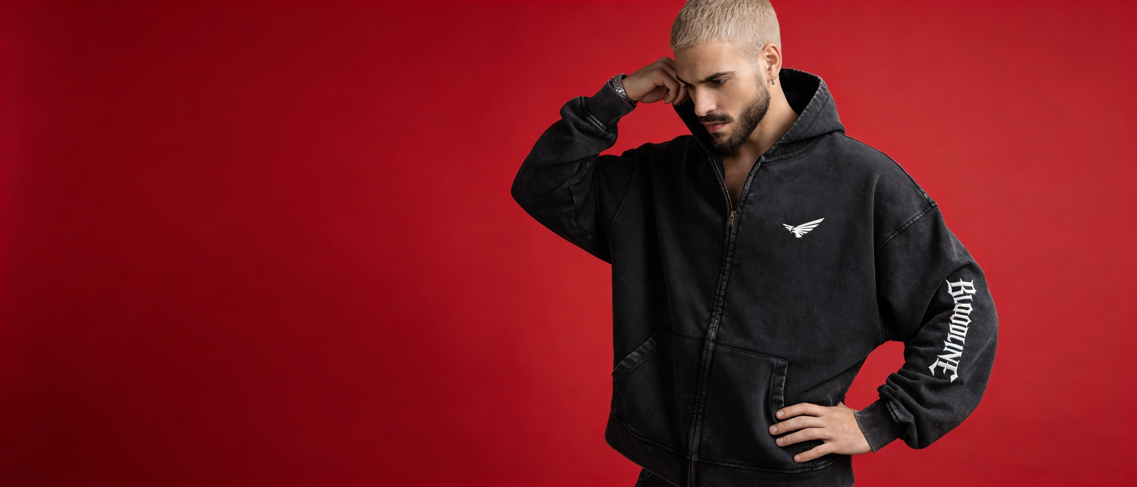 Man wearing a black hoodie with branding on a red background