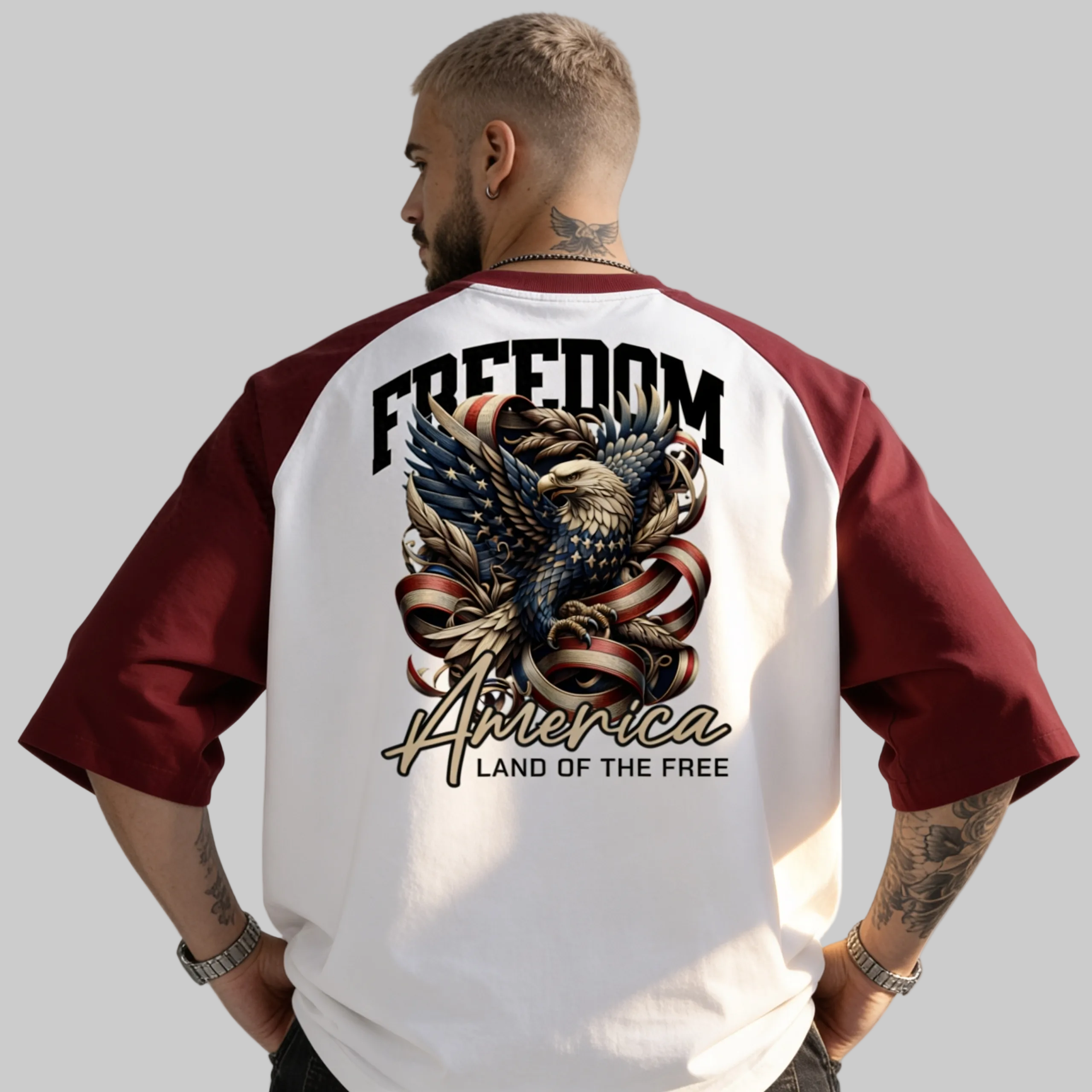 Person wearing a white and red baseball jersey with an eagle design and text on the back.