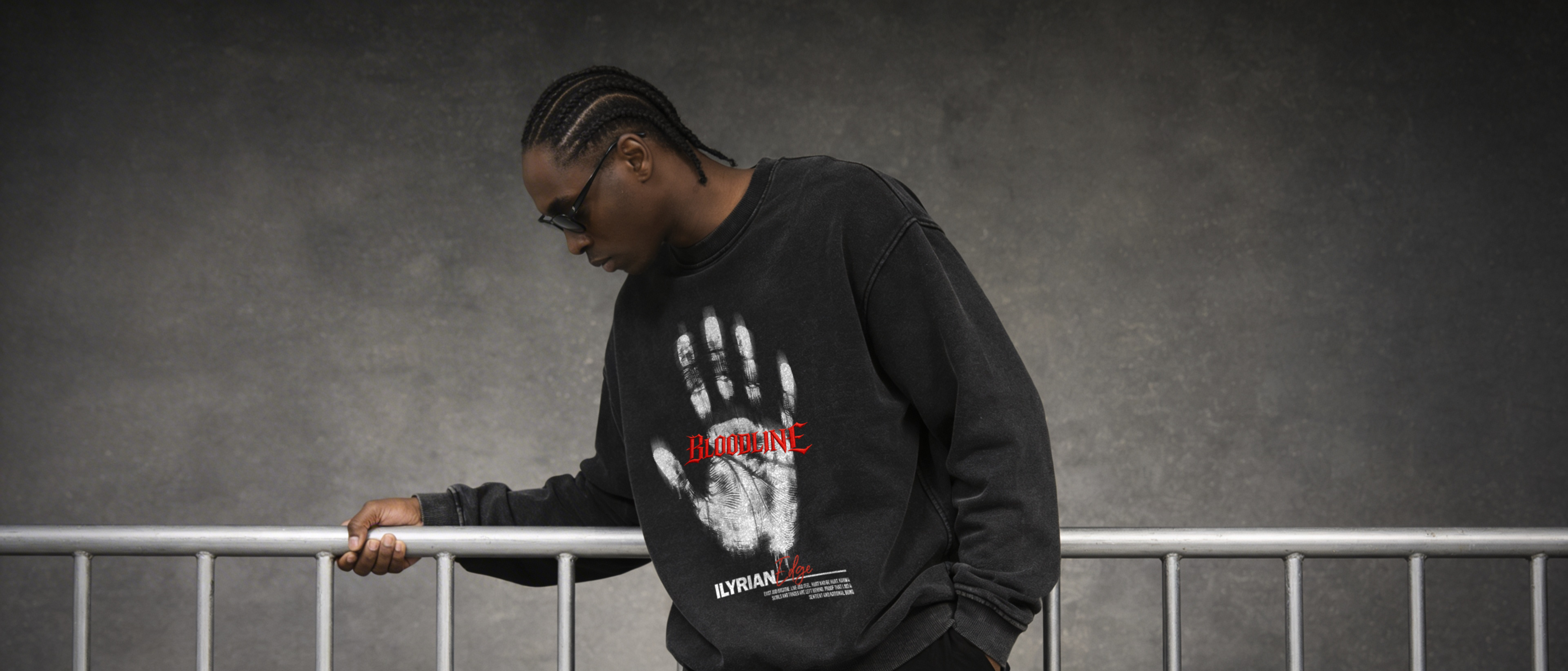 Person wearing a black sweatshirt with a handprint design against a gray background