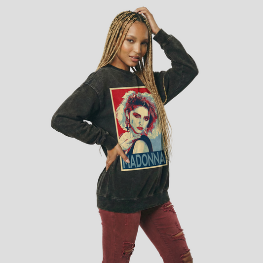Woman wearing a black sweatshirt with a graphic of a woman's face and 'Madonna' text on a white background