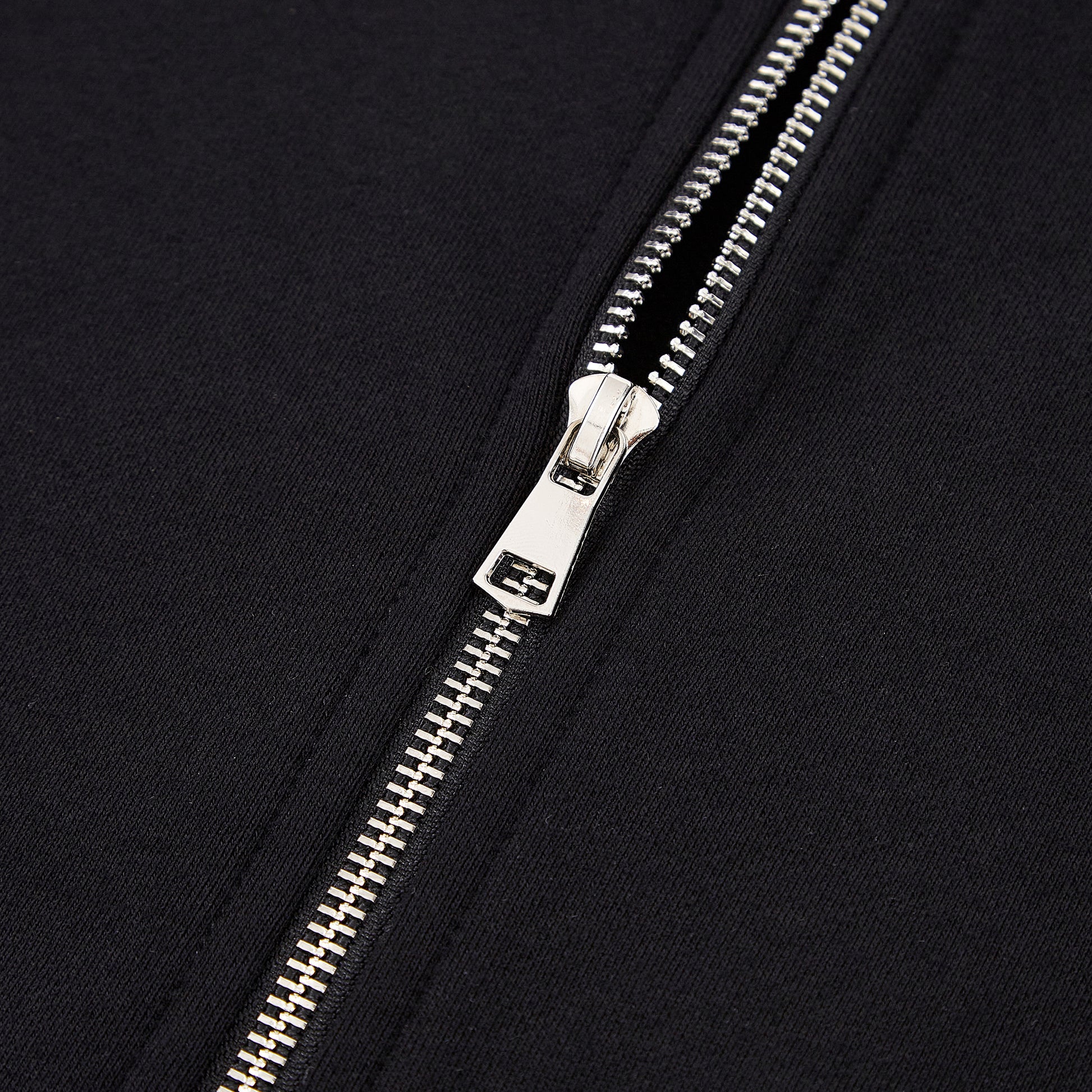 Close-up of a silver zipper on a black background
