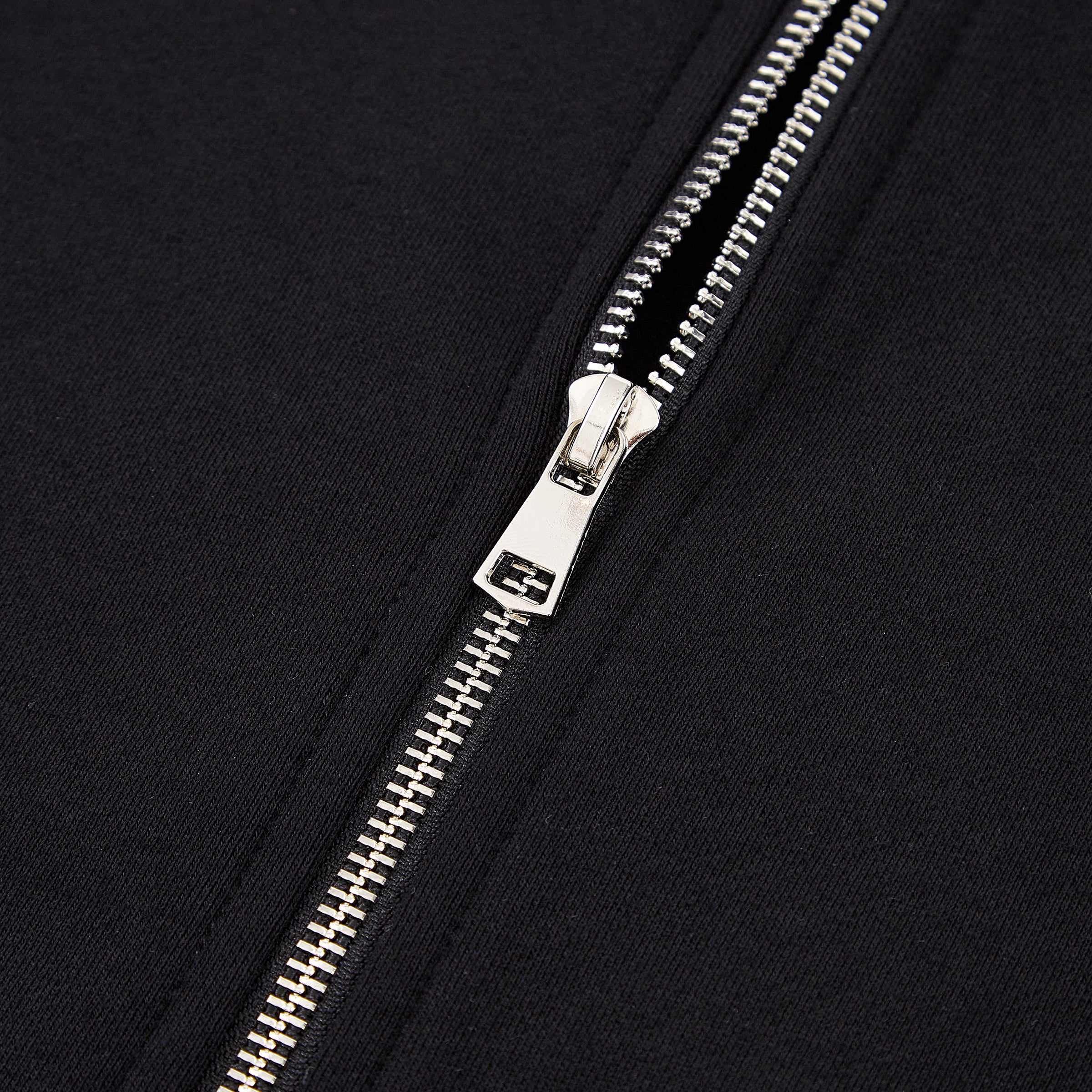 Close-up of a silver zipper on a black background