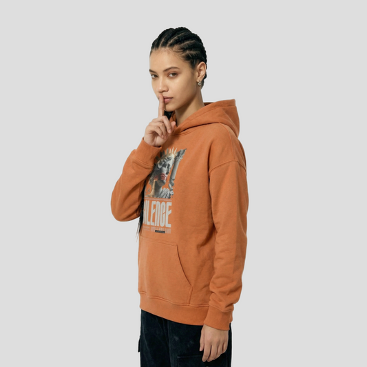 Person wearing an orange hoodie with a graphic design on a white background