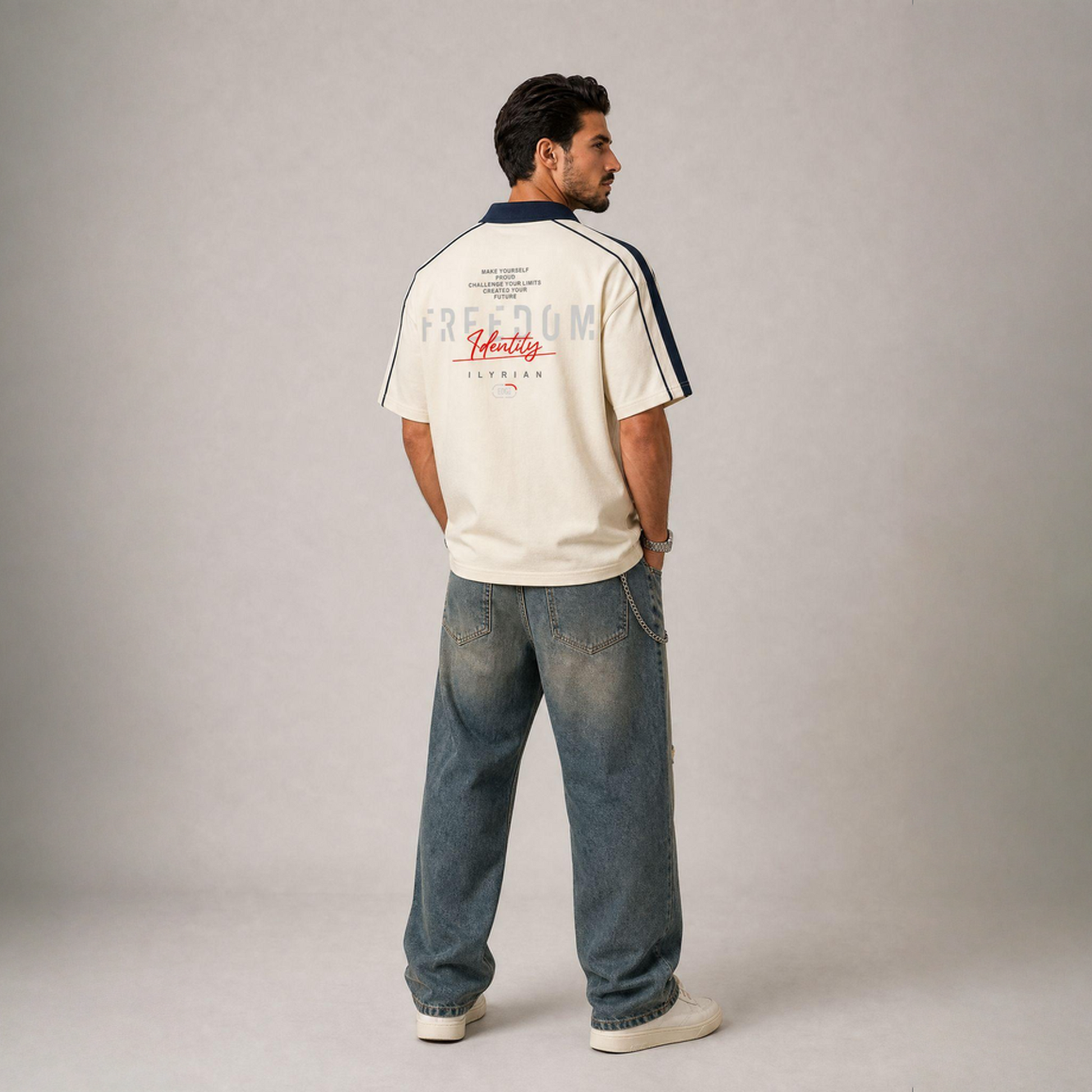 Man wearing a white t-shirt with text and blue jeans on a plain background